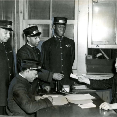 Porters Winslow (no other name available); Jean Napoleon Maurice, Sam Morgan and (seated) James Thompson get their assignments from W.A. Gough, sleeping agent at Windsor station in Montreal in August 1944. Until the 1950s, most black men in Montreal worked for the railway companies as sleeping car porters, red caps and some categories of dining car employees, historian Steven High writes.