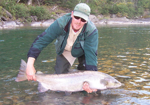 Glenn Harrison, local guide, releasing salmon back into the river. Catch and release, as this practice is called, is becoming a way of life on the Cascapedia, and is considered a responsible choice to ensure the future of fishing on the river. (Photo - Cascapedia River Museum Collection)
