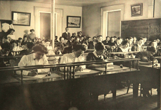 <strong>HIGHER EDUCATION.</strong>
Photograph, c. early 1900s, possibly depicting an examination in progress. Note the teachers standing at the rear. (Compton County Museum Collection / Farnsworth Family Fonds)

