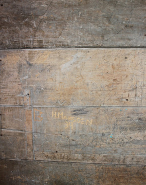 In the narrow vestibule of the schoolhouse, generations of students and visitors have carved or scrawled their names on the rough wooden walls. These have been preserved. (Photo - Matthew Farfan)