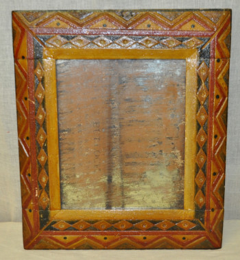 Mirror with hand carved frame, c.1800-1810.
The frame of the mirror was carved with a pocket knife by a slightly disinterested teacher named "Mr. Mitchell" while he listened to the students of Philipsburg recite their lessons. (Missisquoi Historical Society Collections)