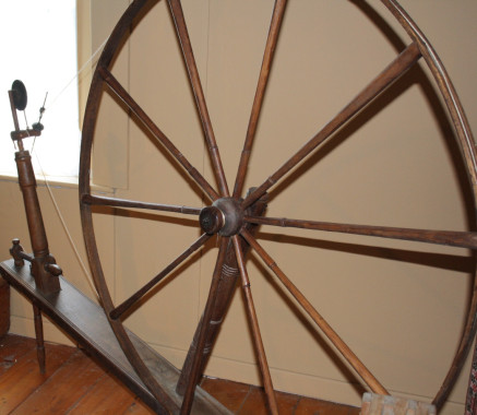 Walking Wheel, c.1860.
The large spinning wheel or "walking wheel" was a common sight in many Quebec homes in the 18th and 19th centuries. The large wheel, used to spin wool, required the spinner to walk back and forth as she wound the woollen thread on to the spindle. It was said that a spinner could walk 20 miles during one day's spinning.
(Missisquoi Historical Society Collections)