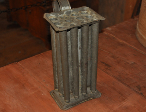 Candle mould, 19th century.
The fat from beef or mutton was rendered to make tallow for candles. This was usually done in a large iron pot over a fire and, if possible, it was done away from the house as the process resulted in a very unpleasant odour. Twisted lengths of cotton were either repeatedly dipped into the hot tallow or tallow was poured into moulds. The process sounds simple enough. However, it was yet another time-consuming and tedious task performed by women. In 1840, Anne Langdon wrote with r