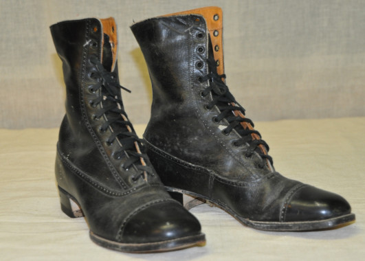 Woman's work boots, c.1890.
"There should be just as much conscience put into dusting as in managing an estate." Godey's Lady's Book, 1870.
One day a week was set aside for general household cleaning and many women took to heart the instructions pronounced in the journals and household guide books of the day. Furniture was draped with dust covers and windows were opened wide to expose hidden dirt. Picture frames, mirrors, furniture and curtains were brushed down with feather dusters. Carpets were 