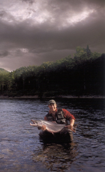 Local guide Jason Ferland, releasing a salmon back into the river. (Photo - Cascapedia River Museum Collection)
