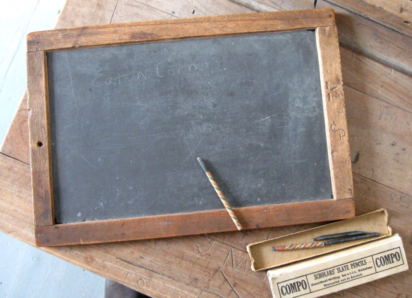<strong>PUPIL'S SLATE BOARD AND SLATE PENCILS.</strong>
Paper was scarce, so earlier schools depended on slate boards. The slate used in these boards may have come from the Kingsbury slate mine in the Eastern Townships. Chalk would not have been used on slate boards. Slate pencils, like those shown in the photo, would have been used. These pencils left a thin, clear line. They are too hard for use on modern chalk boards. (Compton County Museum Collection / Photo - Jackie Hyman)
