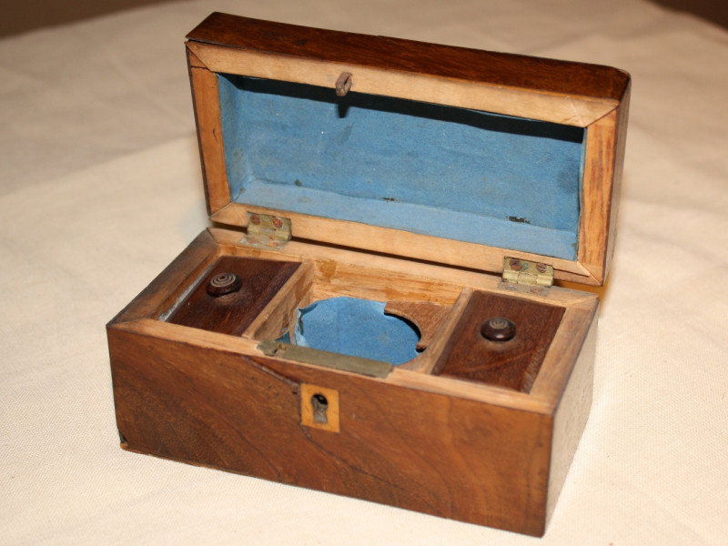 Small wooden Tea Box, lined in blue paper, c.1780.
Tea was considered a luxury and deemed precious enough to keep under lock and key; two compartments inside contained black and green tea. The caddy belonged to Ruth Briggs Spencer who settled in Frelighsburg at the end of the American Revolution. (Missisquoi Historical Society Collections)