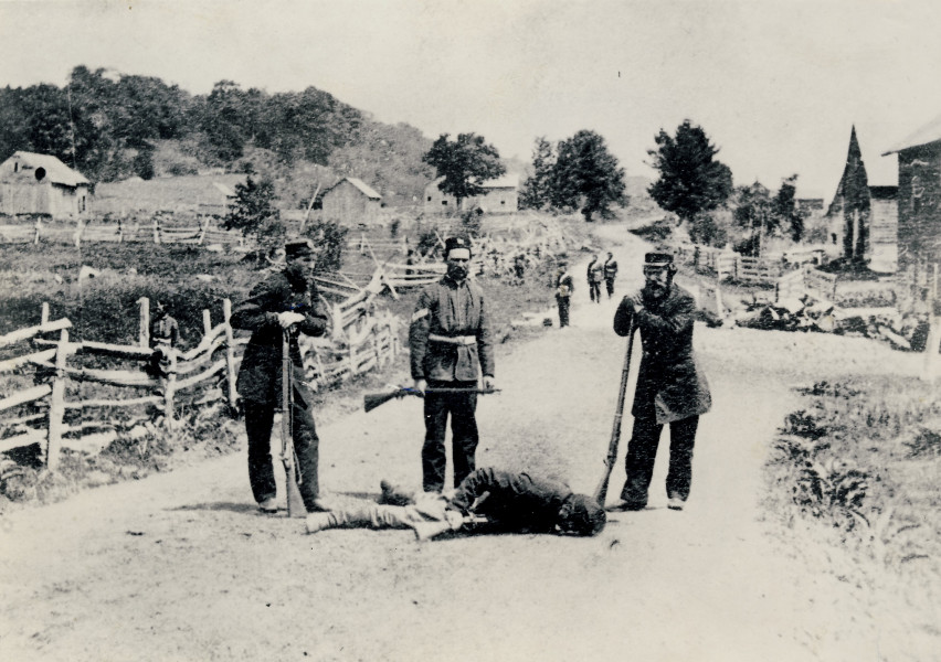 Border Volunteers stand over a Fenian slain during the Battle of Eccles Hill, 1870. (Missisquoi Historical Society Collections)