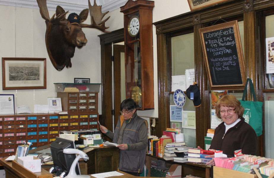 The staff at the Haskell are international. The moose, seen here overlooking the circulation desk, is sporting the latest in border fashion -- a Haskell baseball cap! (Photo - Matthew Farfan)